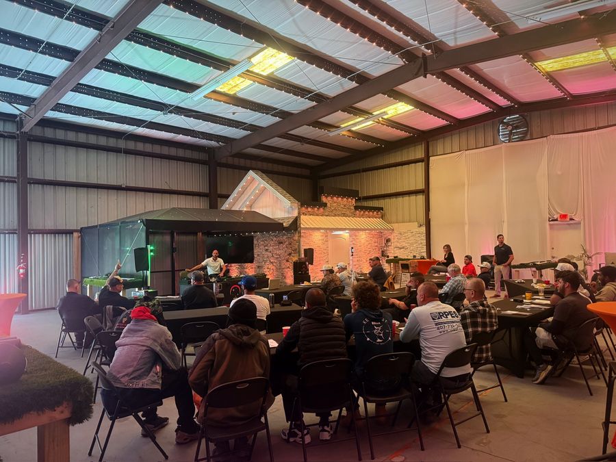 A full class of contractors seated at tables during a Masters of Lighting Academy session in the Brighter Nights training space