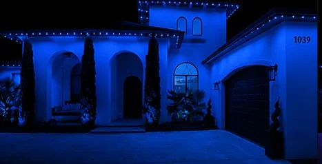 The home washed edge to edge in solid blue from the roofline fixtures