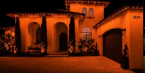 The home washed edge to edge in solid orange from the roofline fixtures