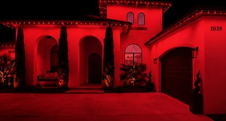 The home washed edge to edge in solid red from the roofline fixtures