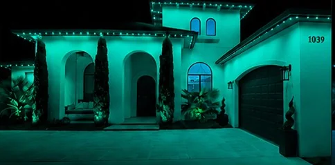 The home washed edge to edge in solid teal from the roofline fixtures