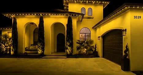 The home washed edge to edge in solid yellow from the roofline fixtures