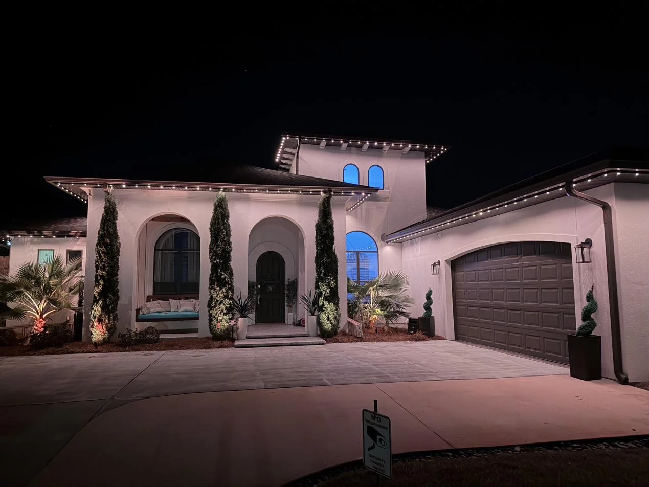 The home at night with warm white permanent roofline lighting on