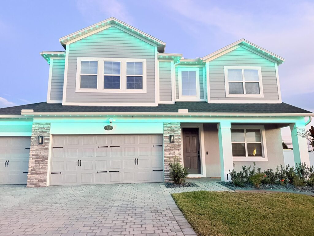 Front of a two story home lit in mint green with roofline lights in Sanford, Florida