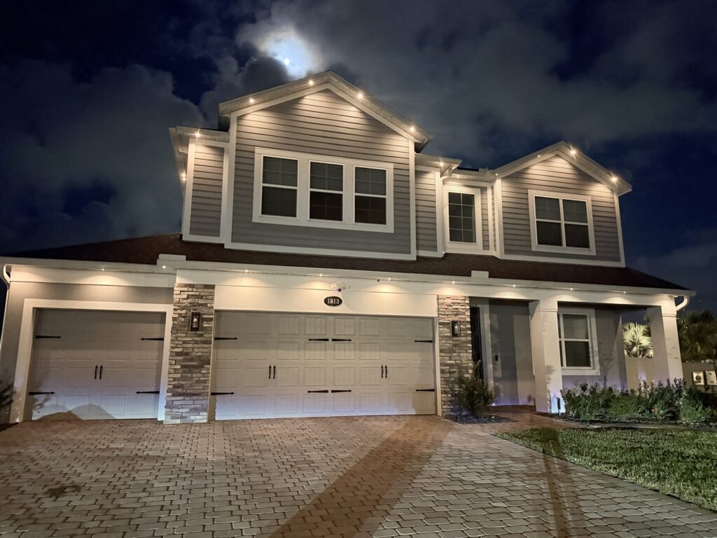 Home with an architectural pattern of lights, one light on and four off, creating a soffit lighting look under a full moon in Sanford, Florida