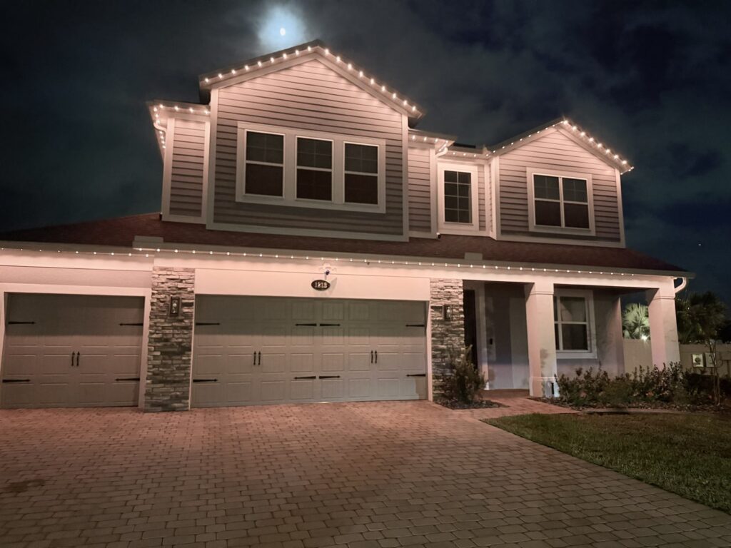 Home with a warm white architectural pattern, one light on and four off, at night in Sanford, Florida