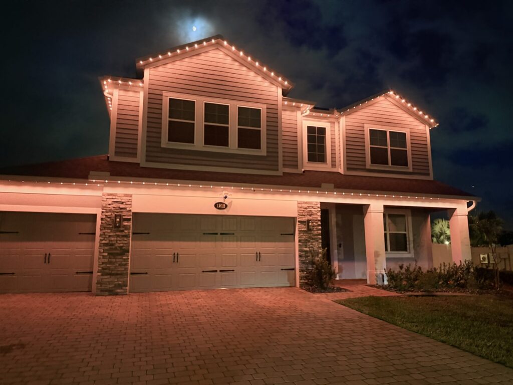 Home with a soft peach and warm white architectural pattern, one light on and four off, at night in Sanford, Florida