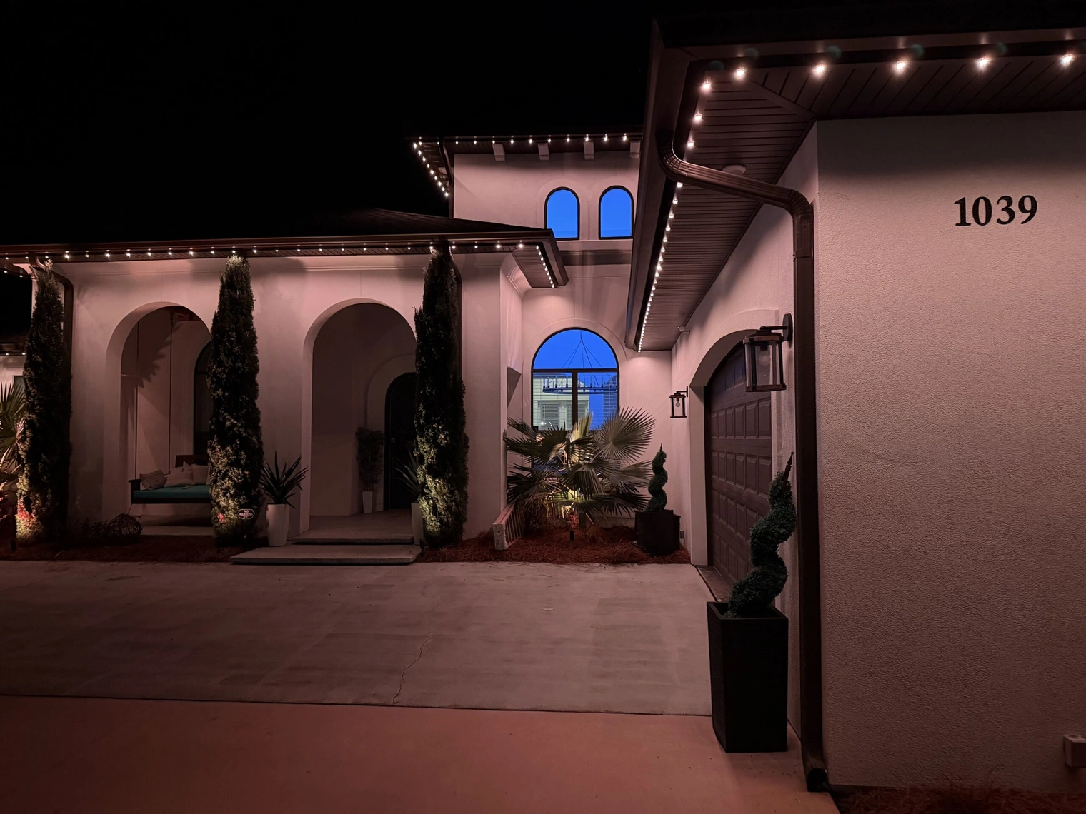 The same home at night with every roofline fixture lit as a full, continuous line of light