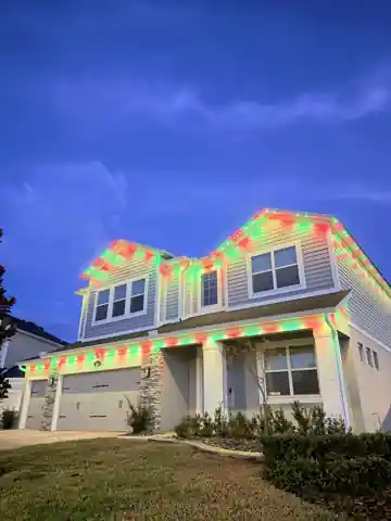 Home with permanent Christmas lights against a deep blue evening sky