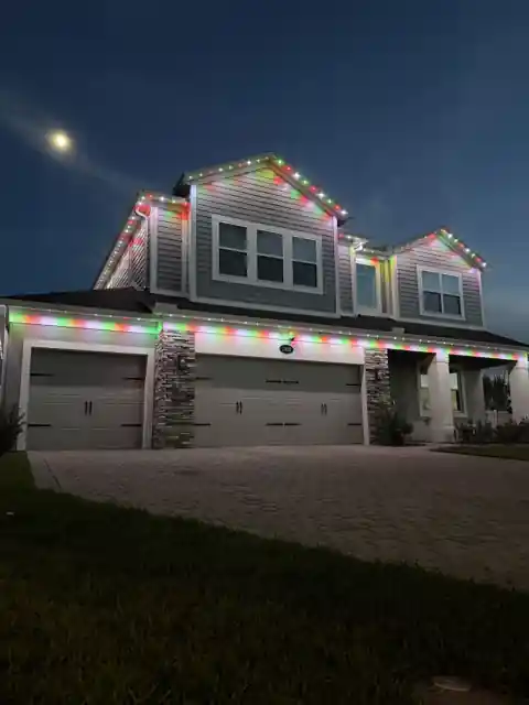 Home at dusk with permanent Christmas lights glowing along the roofline