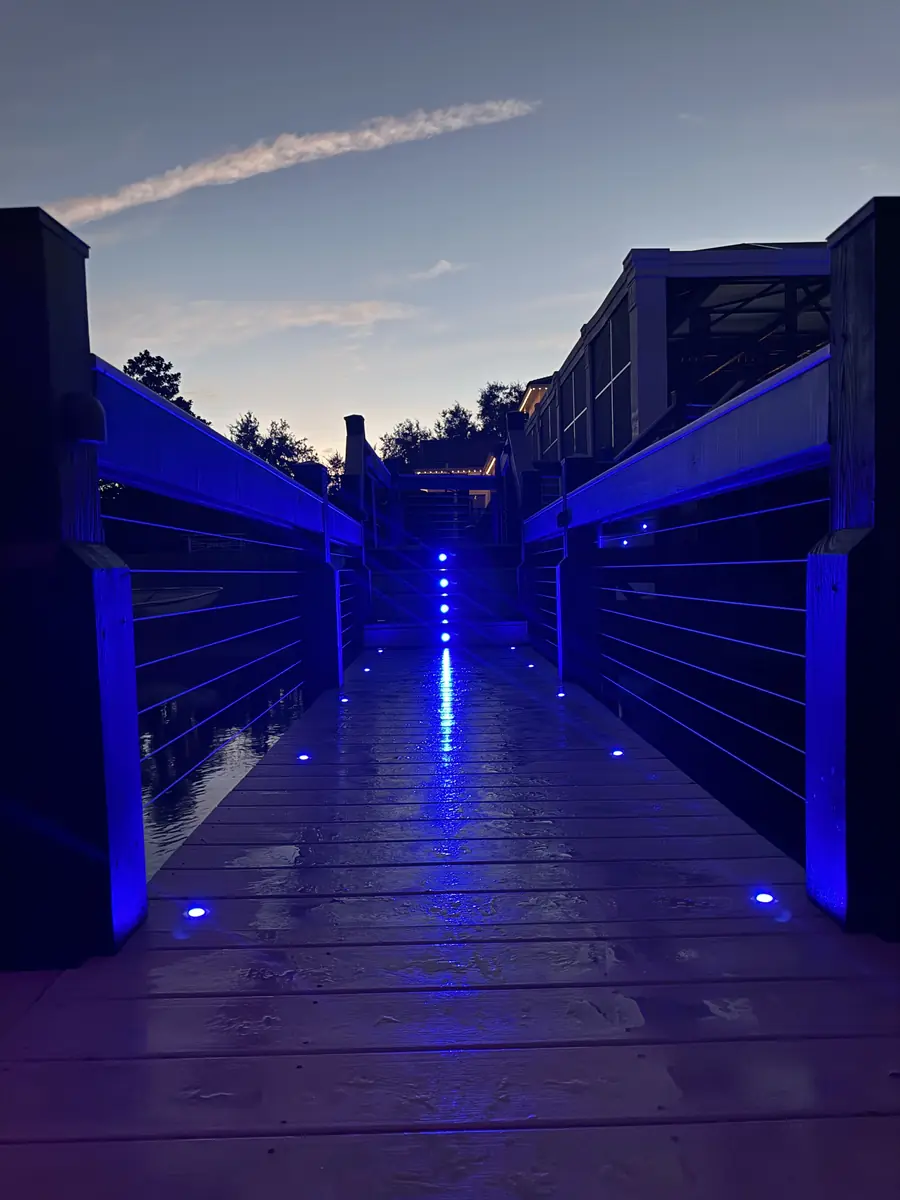 Dock walkway lit in indigo — late night