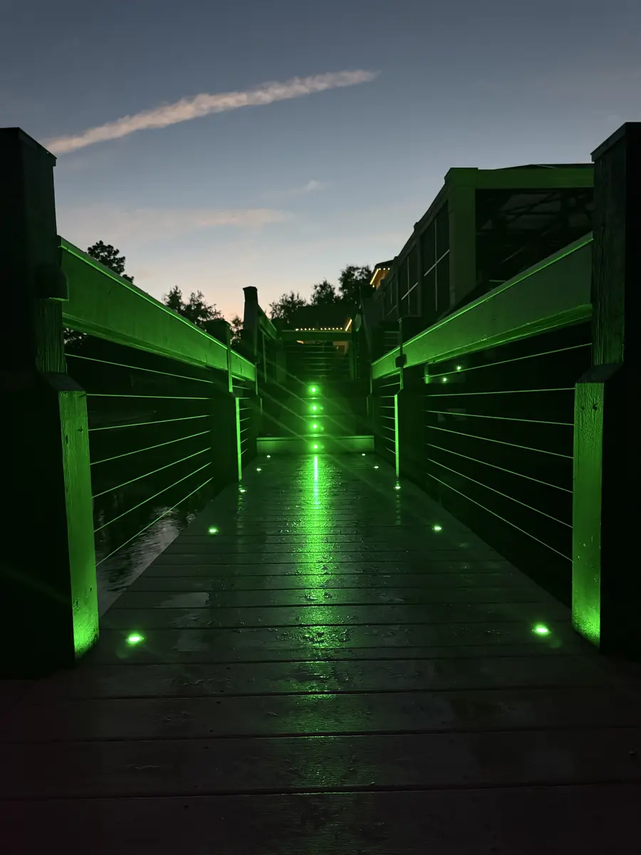 Dock walkway lit in teal — calm
