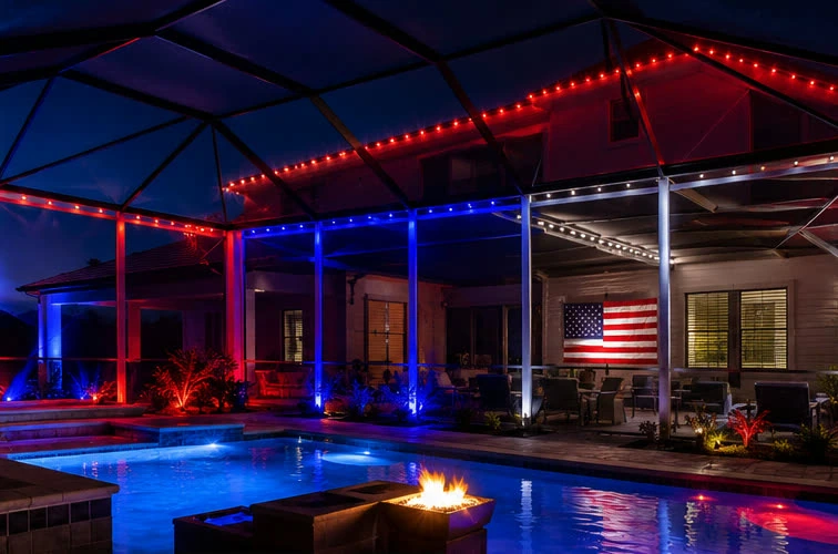 Una jaula de piscina iluminada en rojo, blanco y azul con una bandera de EE. UU. en la pared para el 4 de julio
