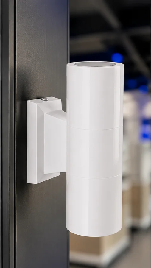 Solid brass sconce in pure white mounted on a dark enclosure post