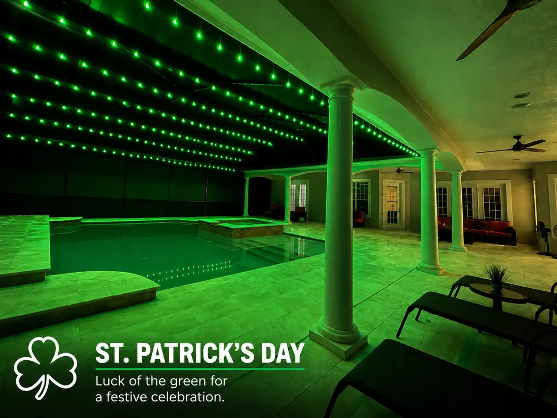 St. Patrick's Day pool enclosure lighting: green BNLT track lights washing a lanai pool at night