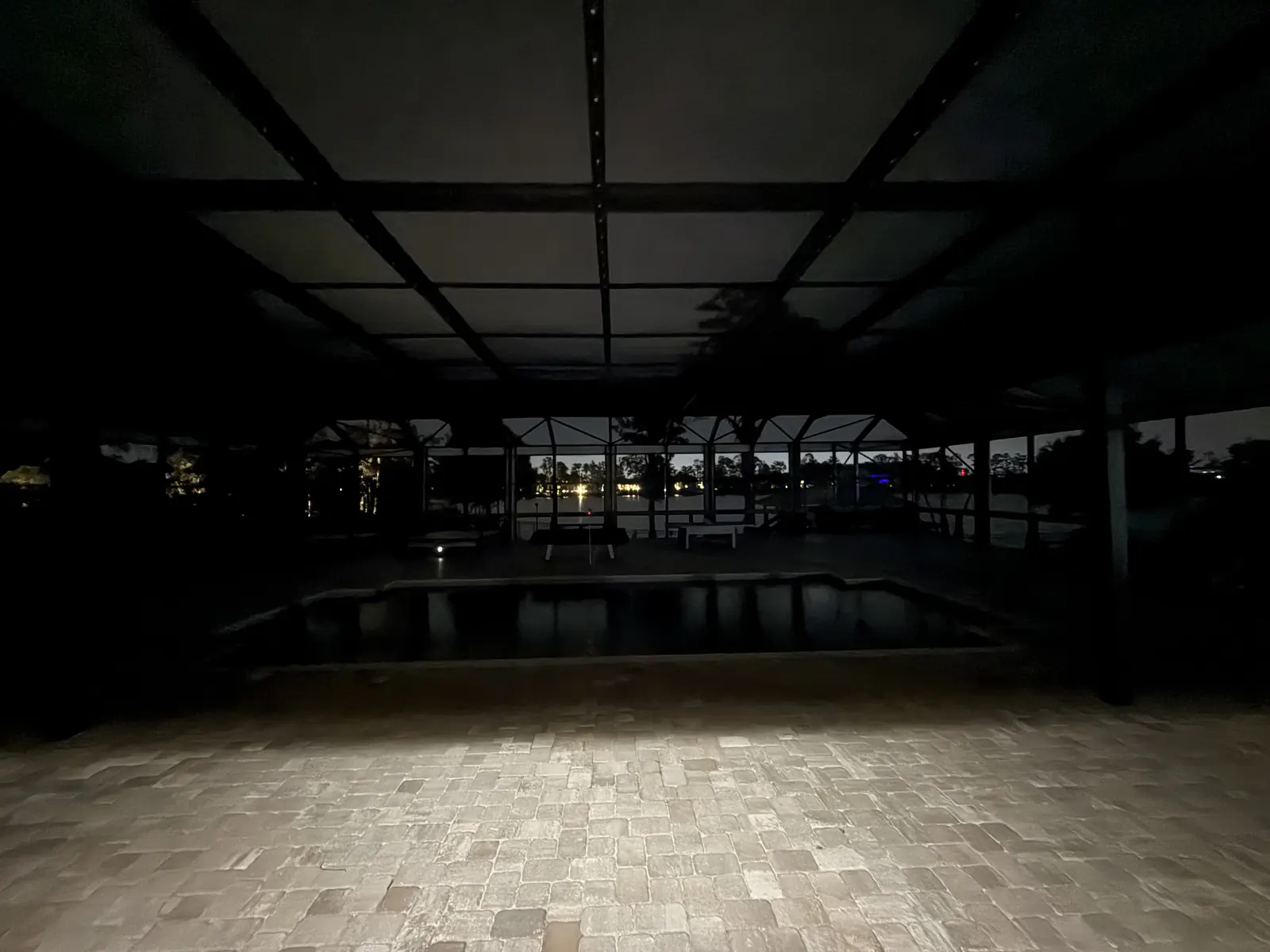 The same pool enclosure at night with the lighting off &mdash; subtle and low-profile in the dark