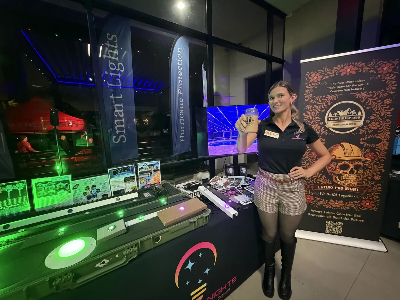 A Brighter Nights team member beside a lit product display at an evening trade show