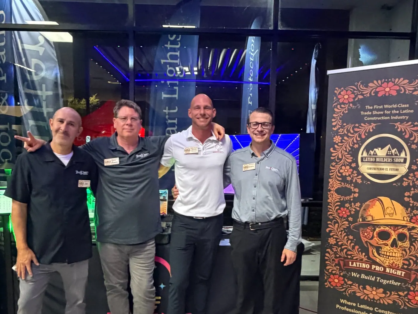 An evening trade event with attendees in front of a lit display